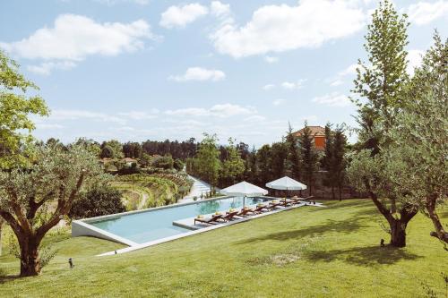 an image of a swimming pool in a garden with trees at Oliveiras Village — Agroturismo in Amarante