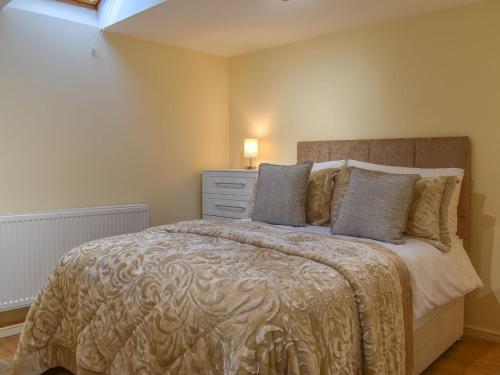 um quarto com uma cama grande e uma cómoda em The Stables At Early Autumn em Eynsford
