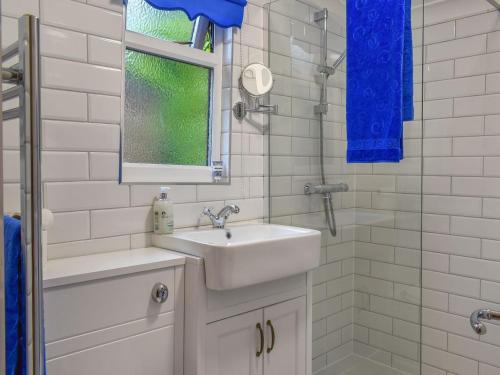 a white bathroom with a sink and a shower at The Stables At Early Autumn in Eynsford