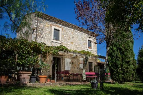 una vieja casa de piedra con un árbol delante en Limosa Country House, en Spigno Saturnia