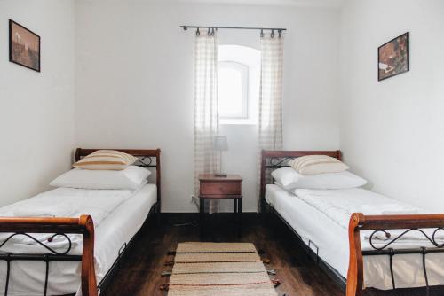2 camas individuales en una habitación con ventana en Folwark, en Wierzchowiska