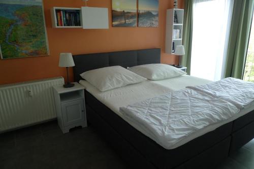 a bed with white sheets and pillows in a bedroom at Appartment 530 in Tossens in Tossenserdeich