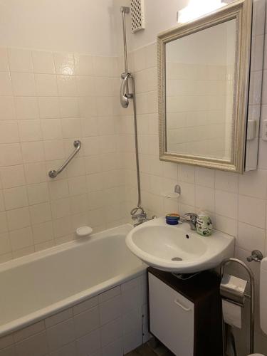 La salle de bains est pourvue d'un lavabo, d'une baignoire et d'un miroir. dans l'établissement Fehmarn Ostseeferien FeWo Südstrand192, à Burgtiefe auf Fehmarn 