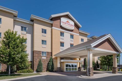 a hotel with a sign on the front of a building at Hawthorn Suites by Wyndham Williston in Williston