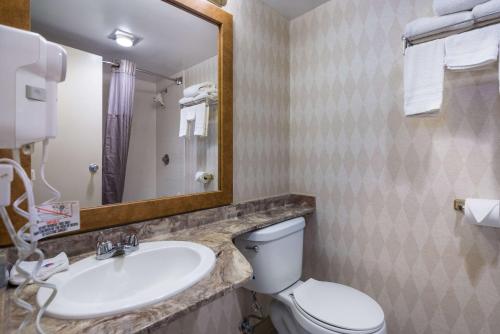 a bathroom with a sink and a toilet and a mirror at Motel 6-Oriskany, NY in Oriskany