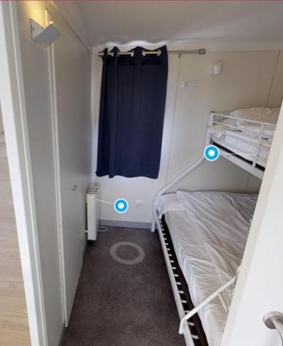 a small room with two bunk beds and blue lights at Bungalows Portuondo parking gratuito in Mundaka