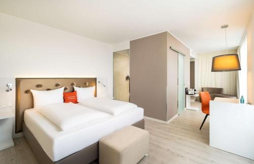 une chambre d'hôtel avec un lit et une chaise dans l'établissement elaya hotel kleve, à Clèves