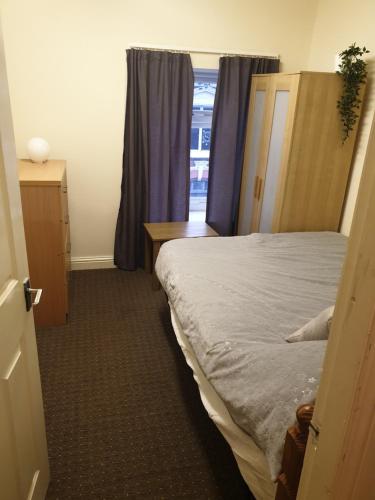 1 dormitorio con cama, mesa y ventana en 2 bedroom apartment in Greater Manchester en Ashton under Lyne