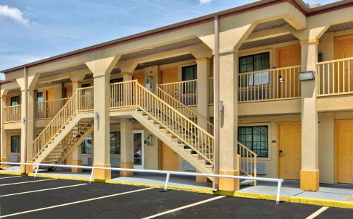 a large apartment building with a staircase in a parking lot at Super 8 by Wyndham Palestine TX in Palestine