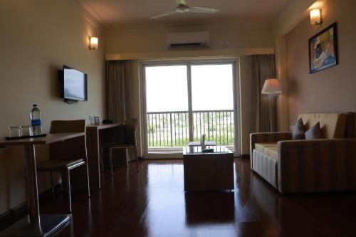 a living room with a couch and a large window at Starlit Suites Tirupati in Tirupati