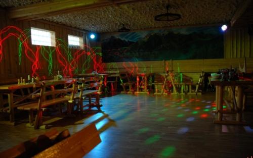a room with tables and chairs and lights on the floor at Grota zbójnicka apartament i pokoje in Gliczarów