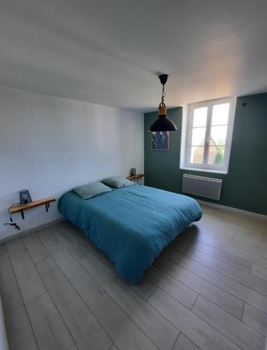 een slaapkamer met een bed met een blauw dekbed bij Maison centre saint Quentin en mauges in Saint-Quentin-en-Mauges