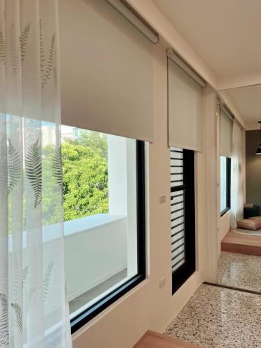 a room with a large window with white blinds at HoME-Easyhouse-III in Tainan