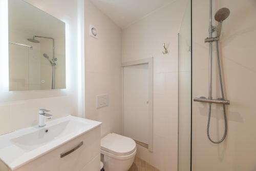 a white bathroom with a shower and a sink at RAVISSANT STUDIO RENOVÉ 150m DE MONACO in Beausoleil