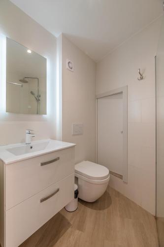 a white bathroom with a toilet and a sink at RAVISSANT STUDIO RENOVÉ 150m DE MONACO in Beausoleil