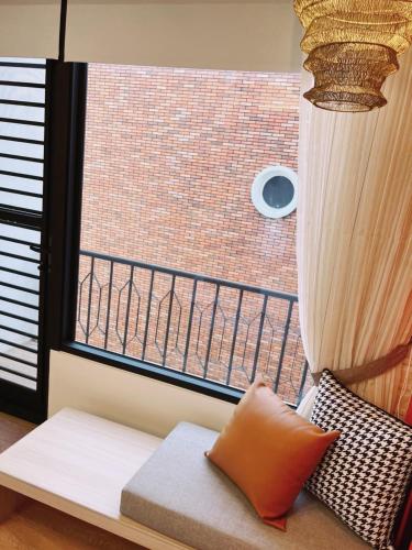 a room with a window with a couch and a balcony at HoME-Easyhouse-III in Tainan