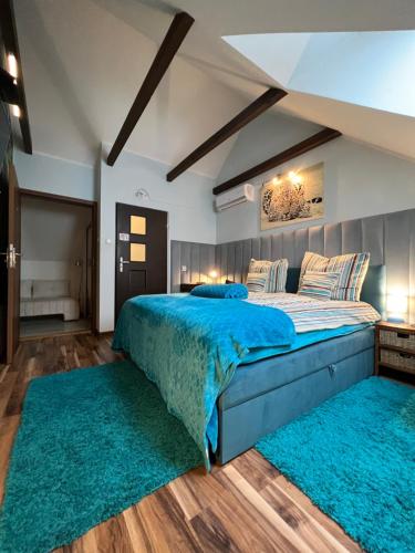 a bedroom with a large bed with green rugs at Comfort Zone Ostróda Apartment 1 in Grabinek