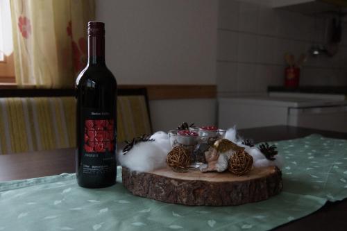 a bottle of wine sitting on a table next to a tree stump at Apart Midi in See