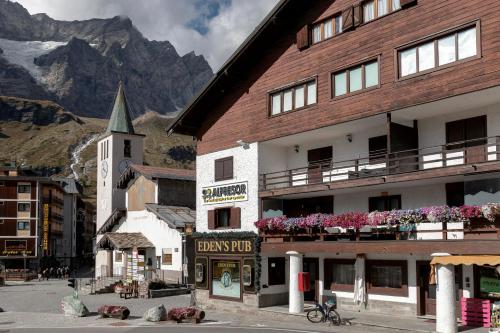 a building with a clock tower and a church at Ski Apartment Francois Hot Tub & Central Location with hotel services in Breuil-Cervinia