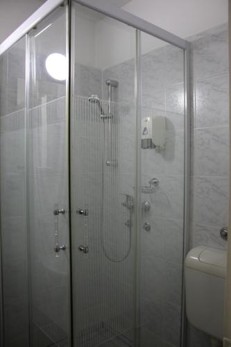 a bathroom with a glass shower with a toilet at Hotel Kristal in Budapest