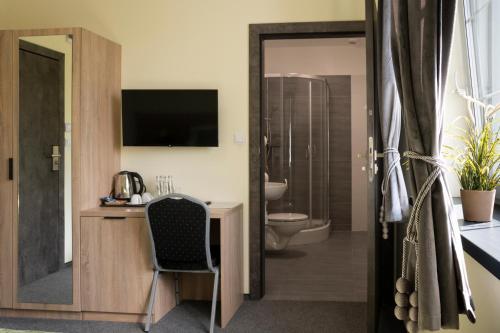 a hotel room with a desk and a bathroom at Przy Skarpie Rozbark in Bytom