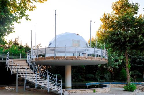 un edificio circular con escaleras en un parque en Layali Al Shams Hotel en ‘Anjar