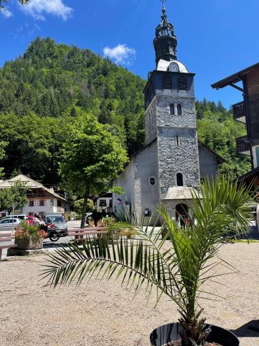 a building with a clock tower on top of it at La Chaumine - Beautiful & Stylish 2 Floor Apartment With Terrace in Montriond