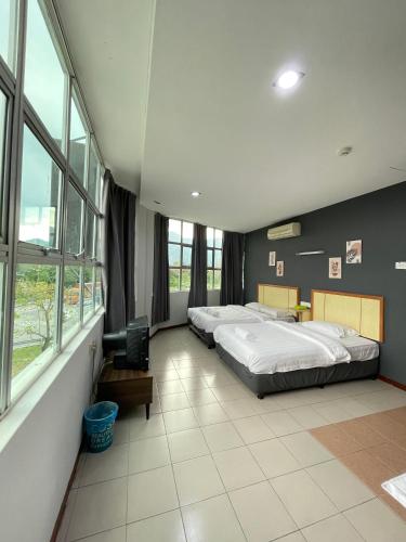 ein großes Schlafzimmer mit 2 Betten und Fenstern in der Unterkunft Fresh Hotel in Ipoh