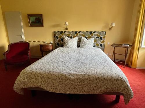 a bedroom with a large bed and a chair at Chambres d´Hôtes Le Cèdre Bleu in Saint-Lattier
