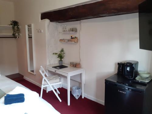 a small room with a desk and a bed and a microwave at The Ivy Barn Holbeton in Plymouth