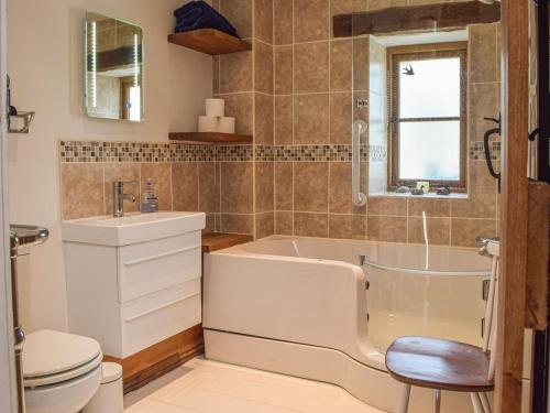 a bathroom with a tub and a toilet and a sink at Swallow Barn in Haverfordwest