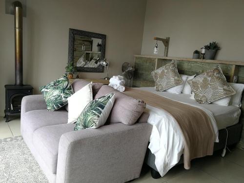 a bedroom with a large bed and a couch at Lavandula Manor Self-Catering in Mossel Bay