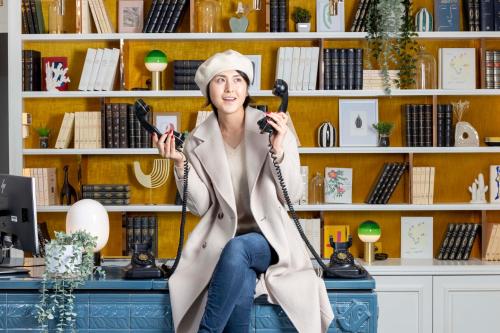 a woman sitting on a desk talking on the telephone at Hotel Louvre Montana in Paris