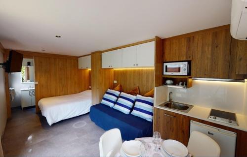 a bedroom with a bed and a kitchen with a sink at Bungalows Portuondo parking gratuito in Mundaka
