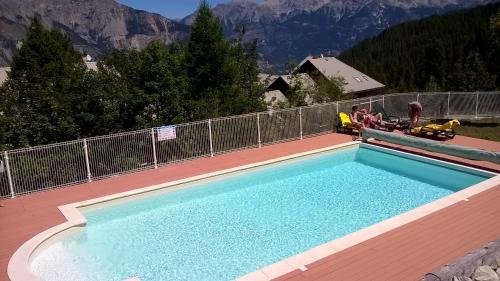 een groot zwembad op een terras met een berg bij T3 puy st Vincent 1800 in Puy-Saint-Vincent