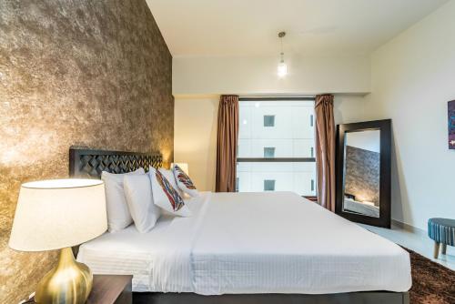 Un dormitorio con una gran cama blanca y una ventana en Icon Casa Living - Sadaf 4 Residence - JBR, en Dubái