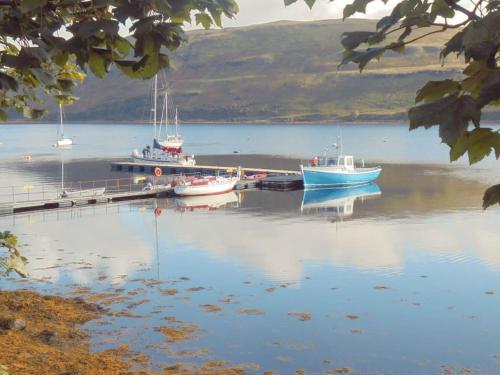 two boats are docked at a dock on a lake at This must be the place - Skye, Carbost in Carbost