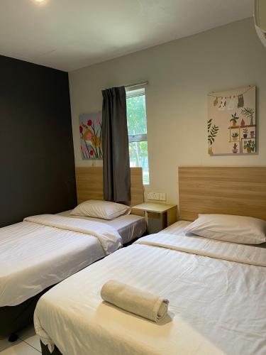 a bedroom with two beds with a towel on the bed at Fresh Hotel Falim in Ipoh