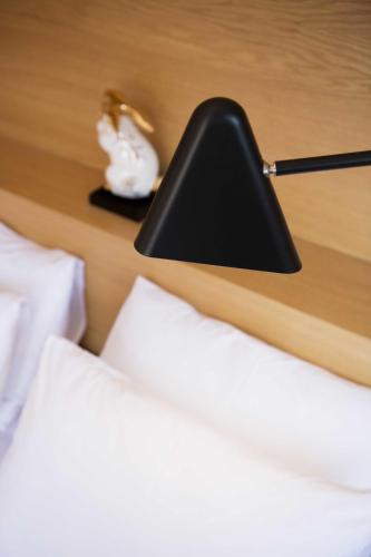 a black lamp sitting on top of a bed at Kumbaracı Apartments & Suites in Istanbul