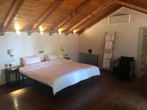 a bedroom with a large white bed and a chair at Zack's Piccolo Comfort in Athens