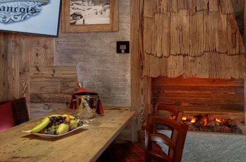 a table with a plate of fruit and a fireplace at Ski Apartment Francois Hot Tub & Central Location with hotel services in Breuil-Cervinia