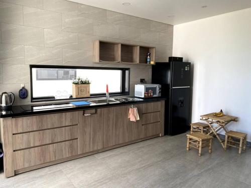 a kitchen with a counter and a sink and a refrigerator at Biệt thự nghỉ dưỡng mặt biển, cao cấp và riêng tư in Ba Ria