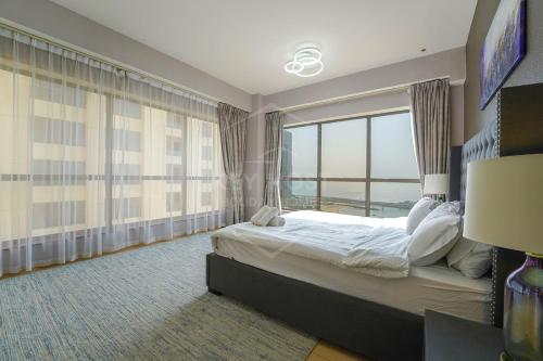 a bedroom with a large bed and a large window at KeyHost - Full Sea View Majestic 2BR Apartment - Rimal JBR - K2530 in Dubai