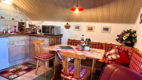 een keuken met een houten tafel met stoelen bij Ferienwohnung und -haus am Rennsteig bei Eisenach - Angela Jaentsch in Wolfsburg-Unkeroda