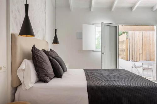 1 dormitorio con cama con almohadas y balcón en Apartamento Caolin Rocabella en El Chorro