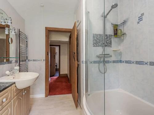 a bathroom with a shower and a tub and a sink at 18th Century Farmhouse, England Wales Border, Breathtaking Views in Oswestry