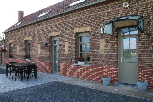 a brick building with a table and chairs on it at Charmante maison de campagne "Chemin Saint-Roch" 