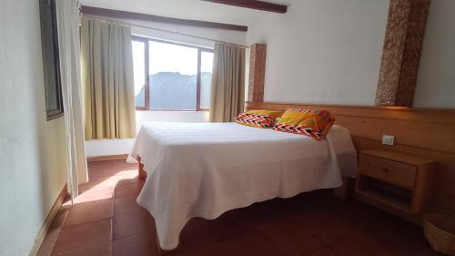 a bedroom with a bed with two pillows on it at Casa Cavoquinho in Paul
