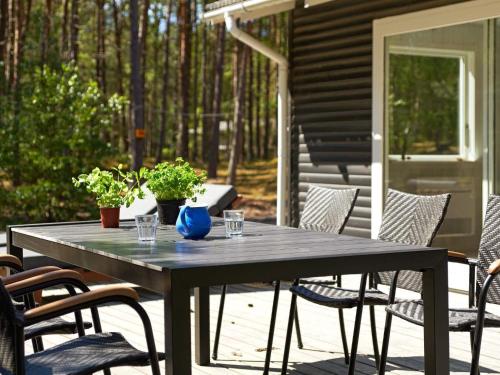 un tavolo in legno su un patio con sedie e piante di 7 person holiday home in Nex a Neksø