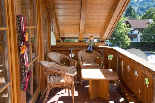 a porch with wicker chairs and a table on a balcony at Golden GaPa Penthouse 1 in Garmisch-Partenkirchen